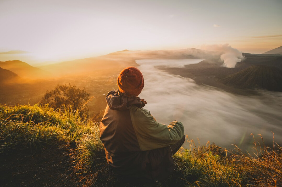 person meditating at sunrise